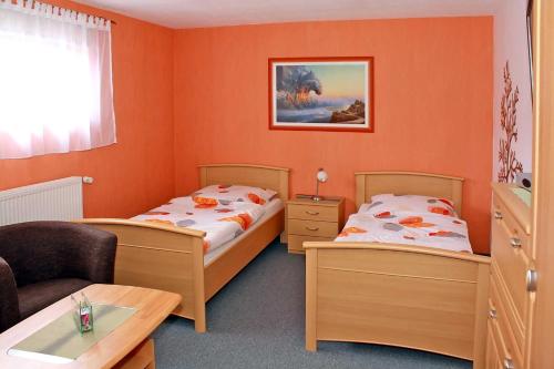 two beds in a room with orange walls at Ferienwohnung Brandshagen in Reinberg
