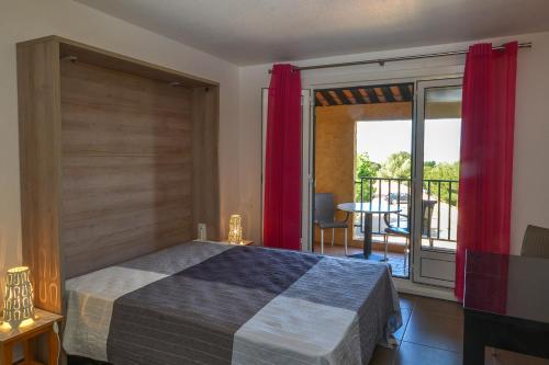 a bedroom with a bed and a view of a balcony at VVF Résidence Saint-Cyr-sur-Mer in Saint-Cyr-sur-Mer
