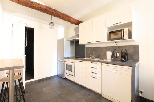 une cuisine avec des placards blancs et un comptoir dans l'établissement Cannes - 2 pièces refait à neuf Palais des festivals - Croisette, à Cannes