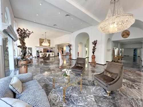 a living room with couches and a chandelier at Hotel Quisisana in Capri
