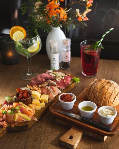 a wooden table topped with plates of food and drinks at Hotel Restaurant D'n Dries in Drunen
