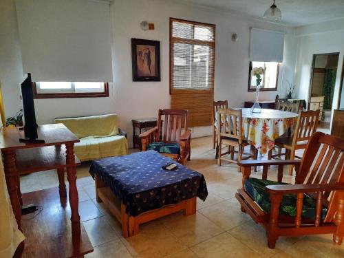 sala de estar con sillas de madera y mesa. en Cedro Departamentos Temporarios en Posadas