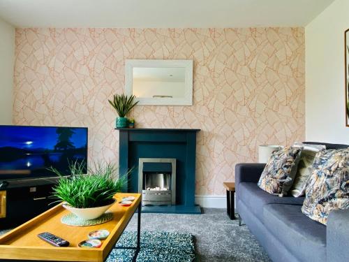 a living room with a couch and a fireplace at Royal Calderdale Lodge in Halifax