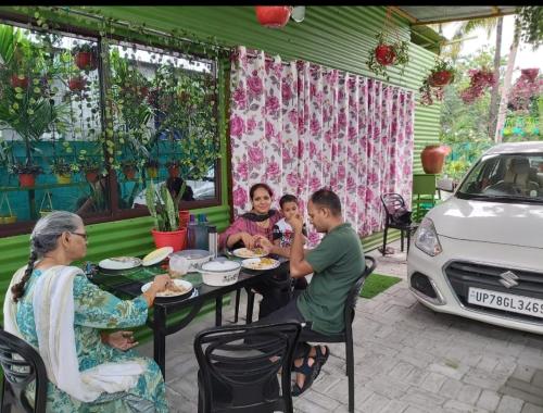 a group of people sitting at a table with a car at GREEN VIEW HOME STAY in Siliguri