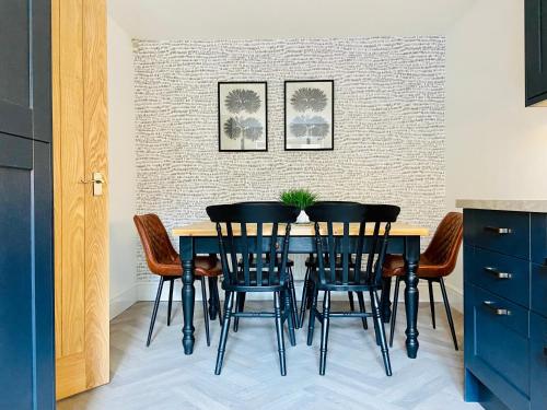 a dining room with a black table and chairs at Royal Calderdale Lodge in Halifax