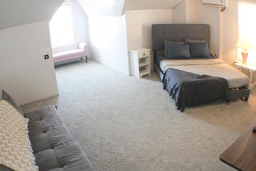 a bedroom with a bed and a couch in it at 3 BR - Off Street Parking - Amazing View Nearby in Pittsburgh