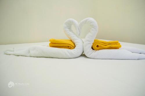 dos toallas en forma de cisnes en una cama en MS Mountain Cabin en Loboc