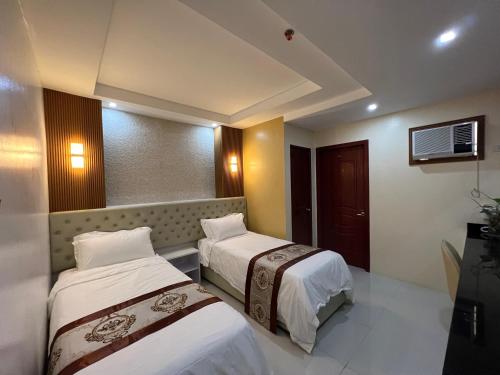pokój hotelowy z dwoma łóżkami i telewizorem w obiekcie Hotel Erich w mieście Tuguegarao