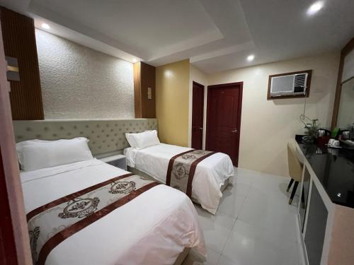 a hotel room with two beds and a television at Hotel Erich in Tuguegarao City