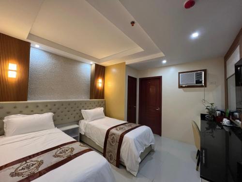 a hotel room with two beds and a television at Hotel Erich in Tuguegarao City