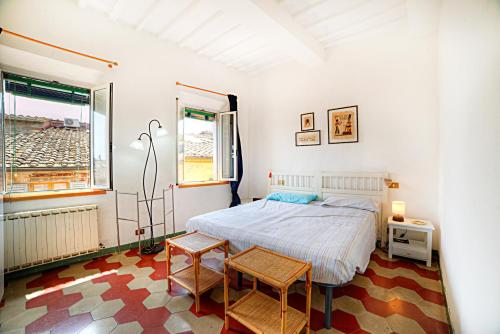 a bedroom with a bed and two chairs in it at La casa di Fa' in Siena