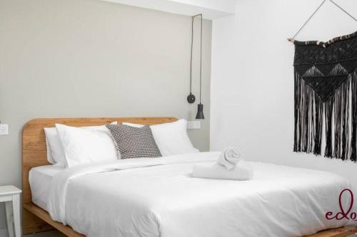 Un dormitorio con una gran cama blanca con almohadas blancas. en דירה עם נוף מדהים 100 מטר מהים חניה פרטית- By Edom, en Eilat