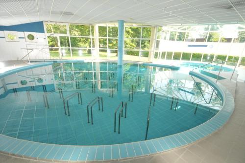 une grande piscine dans un immeuble dans l'établissement Residence Les Chenes, à Saint-Paul-lès-Dax