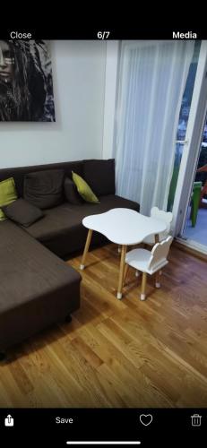 een woonkamer met een witte tafel en een bank bij Laki&Uki in Herceg-Novi