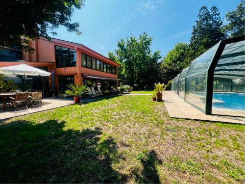 une maison en verre avec une cour et une piscine dans l'établissement Galicia Getaway - Villa Comorera, à Vilagarcía de Arousa
