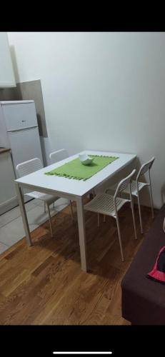 uma mesa com duas cadeiras e uma mesa com uma toalha de mesa verde em Laki&Uki em Herceg Novi