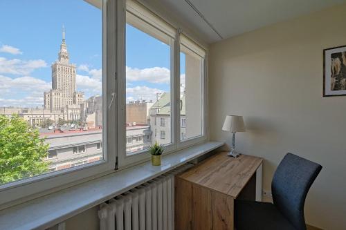 a window seat with a desk and a view of the city at Noctis City Center in Warsaw