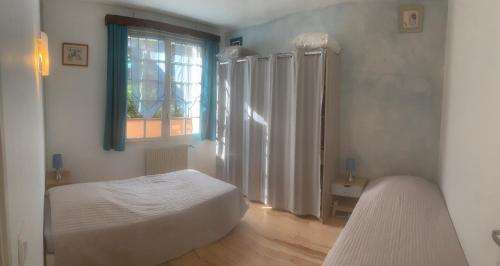 une chambre blanche avec un lit et une fenêtre dans l'établissement Villa la Bergerie, à Bormes-les-Mimosas