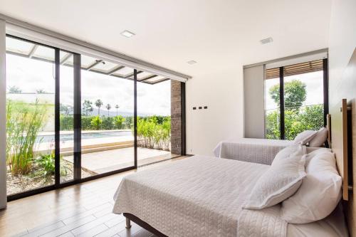 una camera da letto con un letto grande e una grande finestra di Espectacular Finca Campestre de descanso a Villavicencio