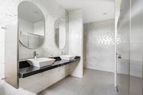 La salle de bains est pourvue de 2 lavabos et d'un miroir. dans l'établissement Espectacular Finca Campestre de descanso, à Villavicencio