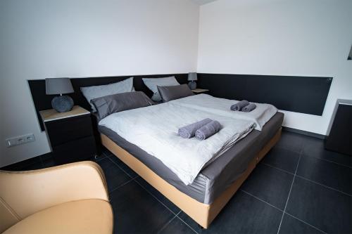 a bedroom with a large bed with two pillows on it at Blauer Stein Apartments WH1 in Pulheim