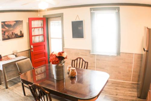 a dining room table with a vase of flowers on it at Comfortable Apartment - Pittsburgh's Little Italy in Pittsburgh