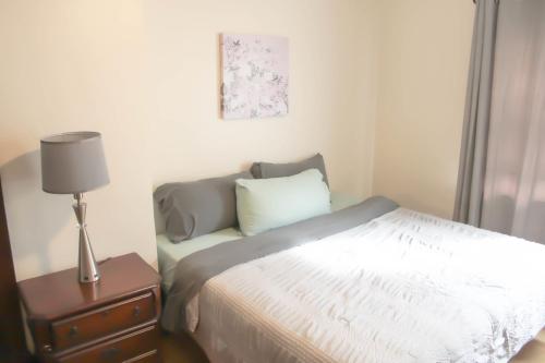 a bedroom with a bed and a lamp on a night stand at Comfy and Spacious 3 BR - Easy City Access in Pittsburgh