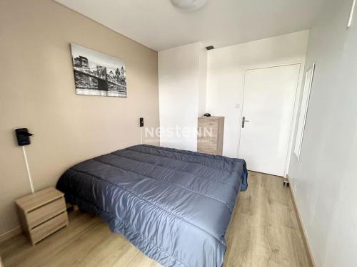 une chambre avec un lit bleu dans une pièce blanche dans l'établissement 2980-Appartement 1 ch à 100m de la mer, à Argelès-sur-Mer