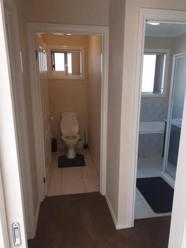 a bathroom with a toilet and a walk in shower at Pacific Werribee Home 25 Min CBD Airport in Werribee