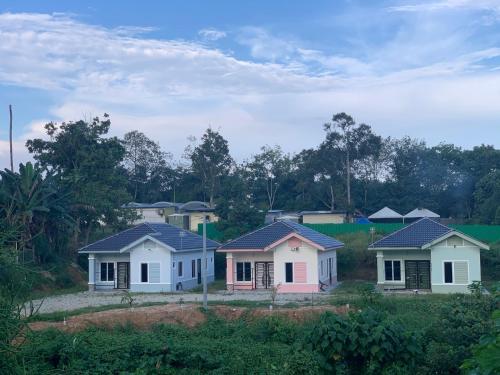 una fila de casas en un campo con árboles en Homestay Dalilah Islam Sendayan, en Seremban