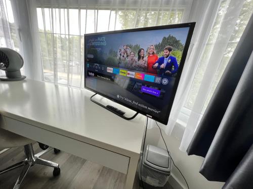 a flat screen tv sitting on top of a desk at Comfortable Double Room for One Person in Bromley
