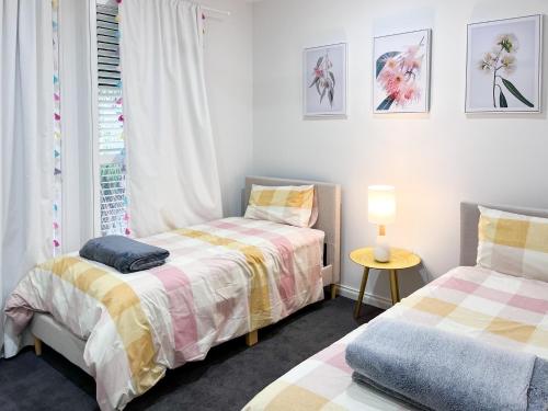 1 dormitorio con 2 camas y ventana en Executive living in City fringe location, en Glenunga