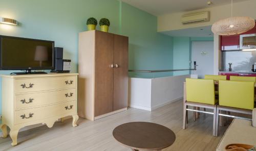 a living room with a tv and a table and chairs at Pestana Alvor Praia Premium Beach & Golf Resort in Alvor