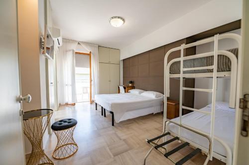 a bedroom with two bunk beds and a room with a table at Albergo Altamira in Roseto degli Abruzzi