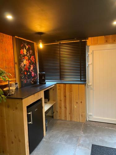 una cocina con armarios de madera y una ventana con barra en Blackroom en Theux