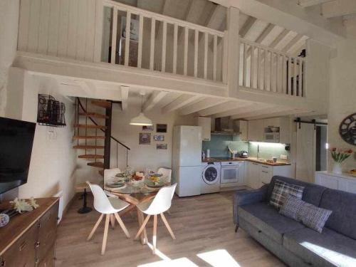 a living room with a couch and a table and chairs at La petite Maison d'Enveitg in Enveitg