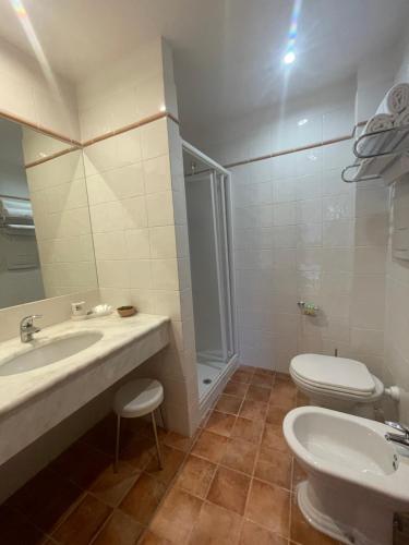 a bathroom with a sink and a toilet and a shower at Hotel La Lampara in Reggio Calabria