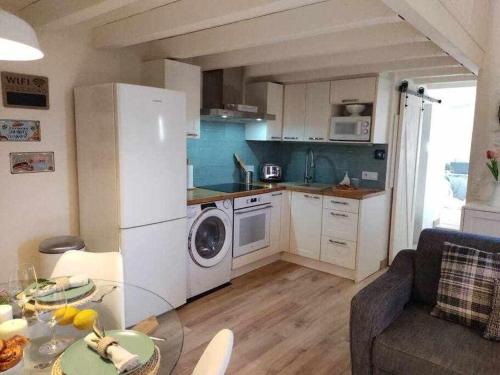 a small kitchen with a white refrigerator and a table at La petite Maison d'Enveitg in Enveitg