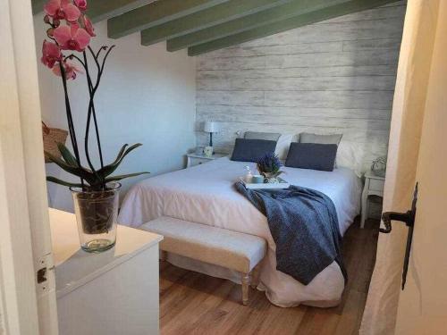 a bedroom with a bed with a vase of flowers at La petite Maison d'Enveitg in Enveitg