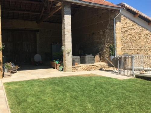 une terrasse d'une maison avec une pelouse dans l'établissement GITE La Maison de Paul et Margaux, à Châteauneuf-de-Galaure