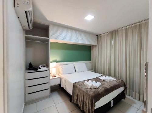 a hotel room with a bed and a dresser with towels at VG Sun Cumbuco Sea Breeze Vista Mar in Cumbuco