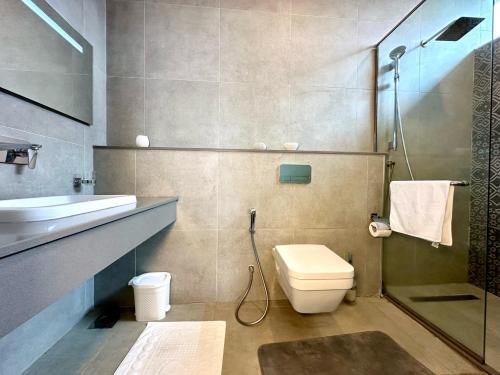 a bathroom with a toilet and a sink and a shower at Skynest - urban luxury apartments by El Mufasa in Nairobi