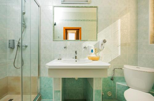 a bathroom with a sink and a toilet and a mirror at Hotel Bystrina in Demanovska Dolina