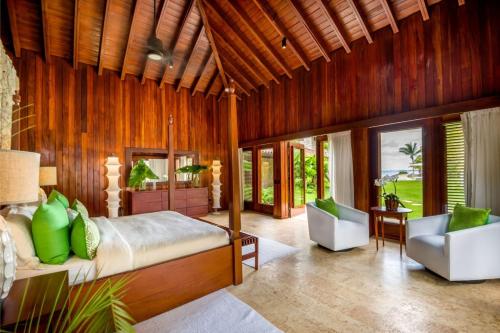 een slaapkamer met een bed en 2 stoelen in een kamer bij Sunny Vacation Villa No 39 in San Rafael del Yuma