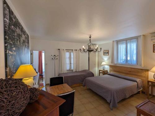 アヴィニョンにあるル ストューディオ ド ラ マドレーヌのベッドルーム1室(ベッド1台、デスク、ソファ付)