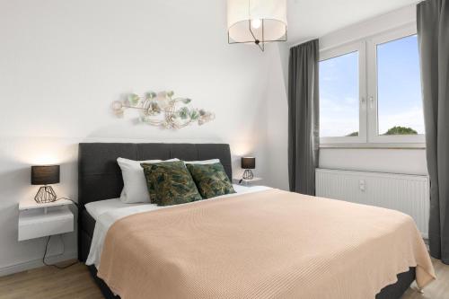 een witte slaapkamer met een bed en een raam bij Design Apartment nah Messe & Rhein I Netflix I Küche in Krefeld