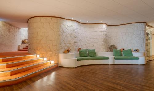 a room with a couch and stairs with green seats at Pestana Alvor Praia Premium Beach & Golf Resort in Alvor