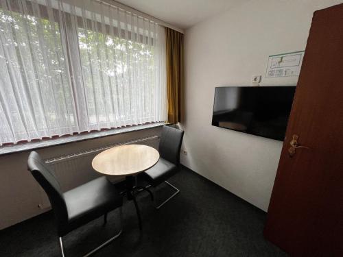 a small room with a table and chairs and a tv at Pension Haus Bambi in Mölln