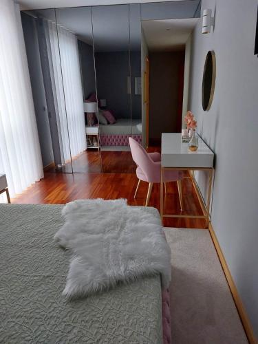 a bedroom with a bed and a desk and a mirror at Appartement en face de la mer in Azurara