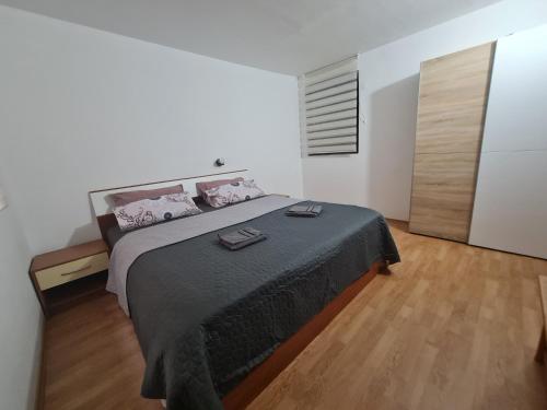 1 dormitorio con 1 cama grande y suelo de madera en Apartmani Jadro en Vir